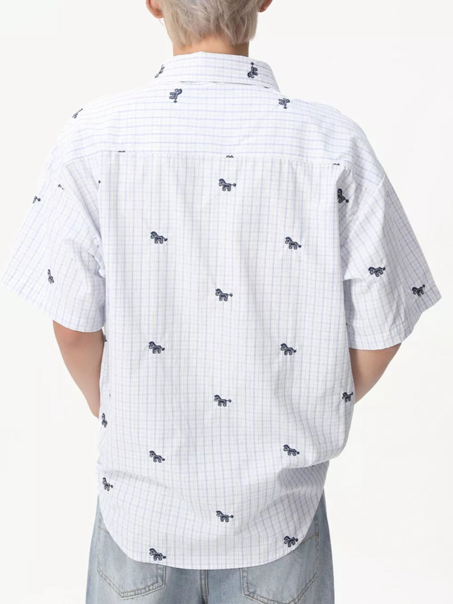 White short sleeve button up shirt with blue plaid and embroidered horse motifs.