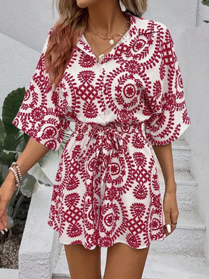 Deep Red printed tie-waist romper with button front and short sleeves.