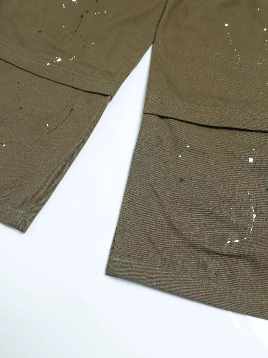 Olive green cotton cargo pants with white and black paint splatter design.