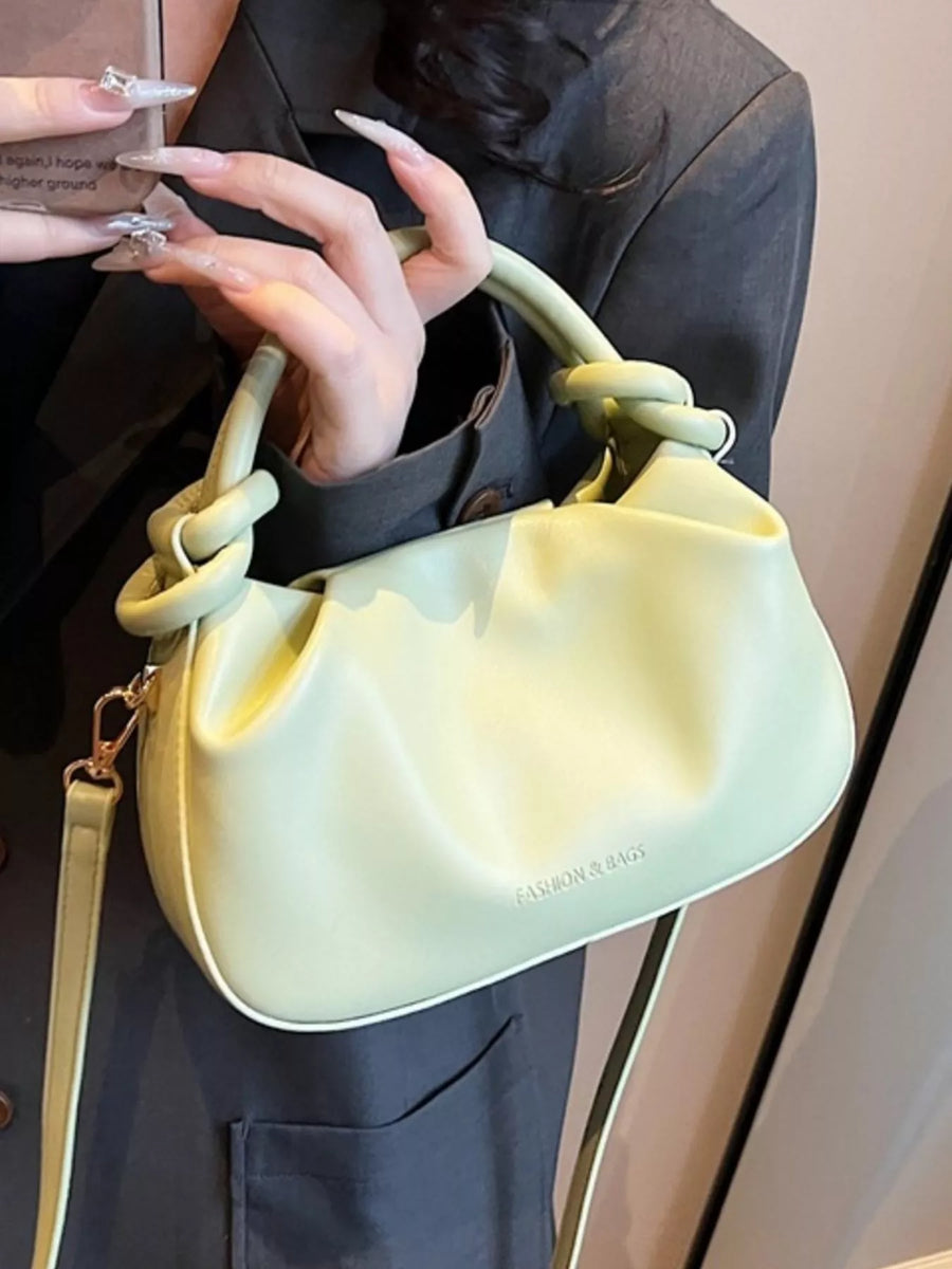 Mini ruched crossbody bag in light green with knotted handles and a detachable strap.