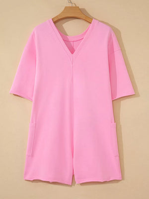 Pink cotton romper with V-neck, half sleeves, and patch pockets.