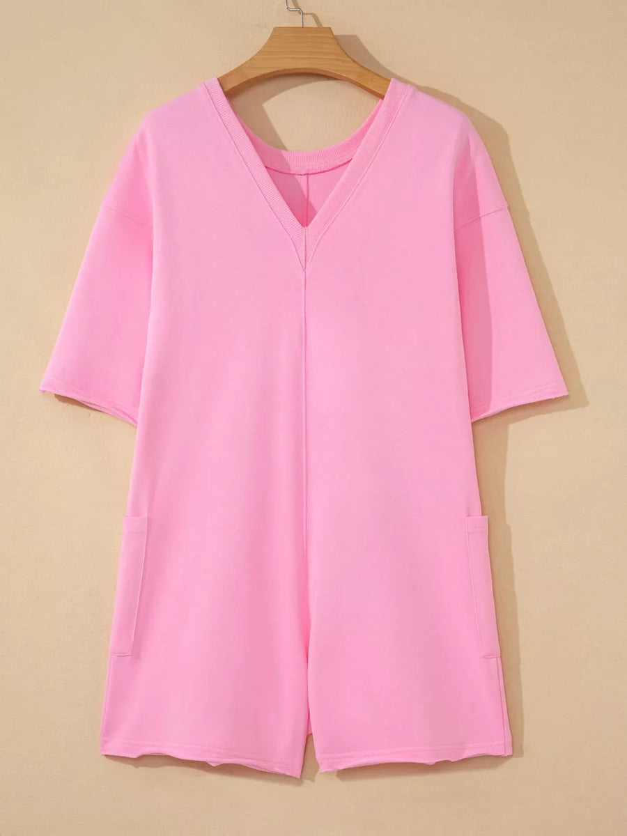 Pink cotton romper with V-neck, half sleeves, and patch pockets.