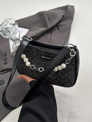 Black shoulder bag with pearl chain detail and glitter accents