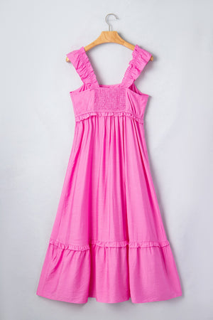 Pink ruffled sleeveless maxi dress with smocked waist and tiered skirt.