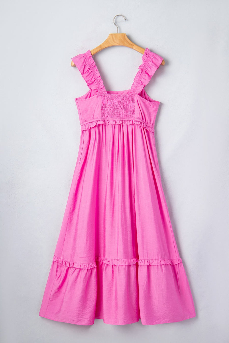 Pink ruffled sleeveless maxi dress with smocked waist and tiered skirt.