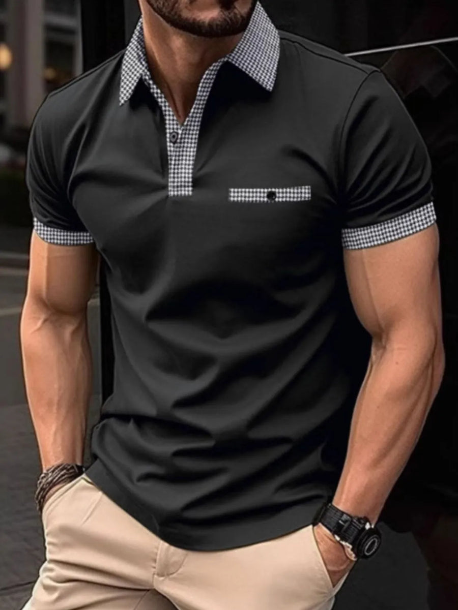 Black polo shirt with gingham collar, pocket trim, and sleeve cuffs.