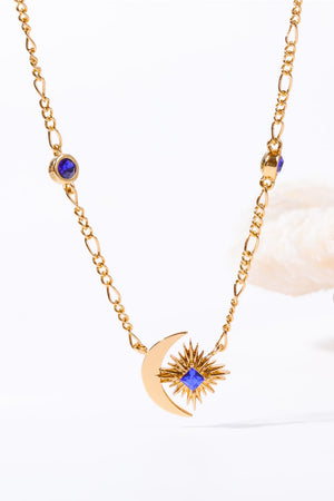 Gold celestial necklace with crescent moon, sunburst charm, and blue gems.