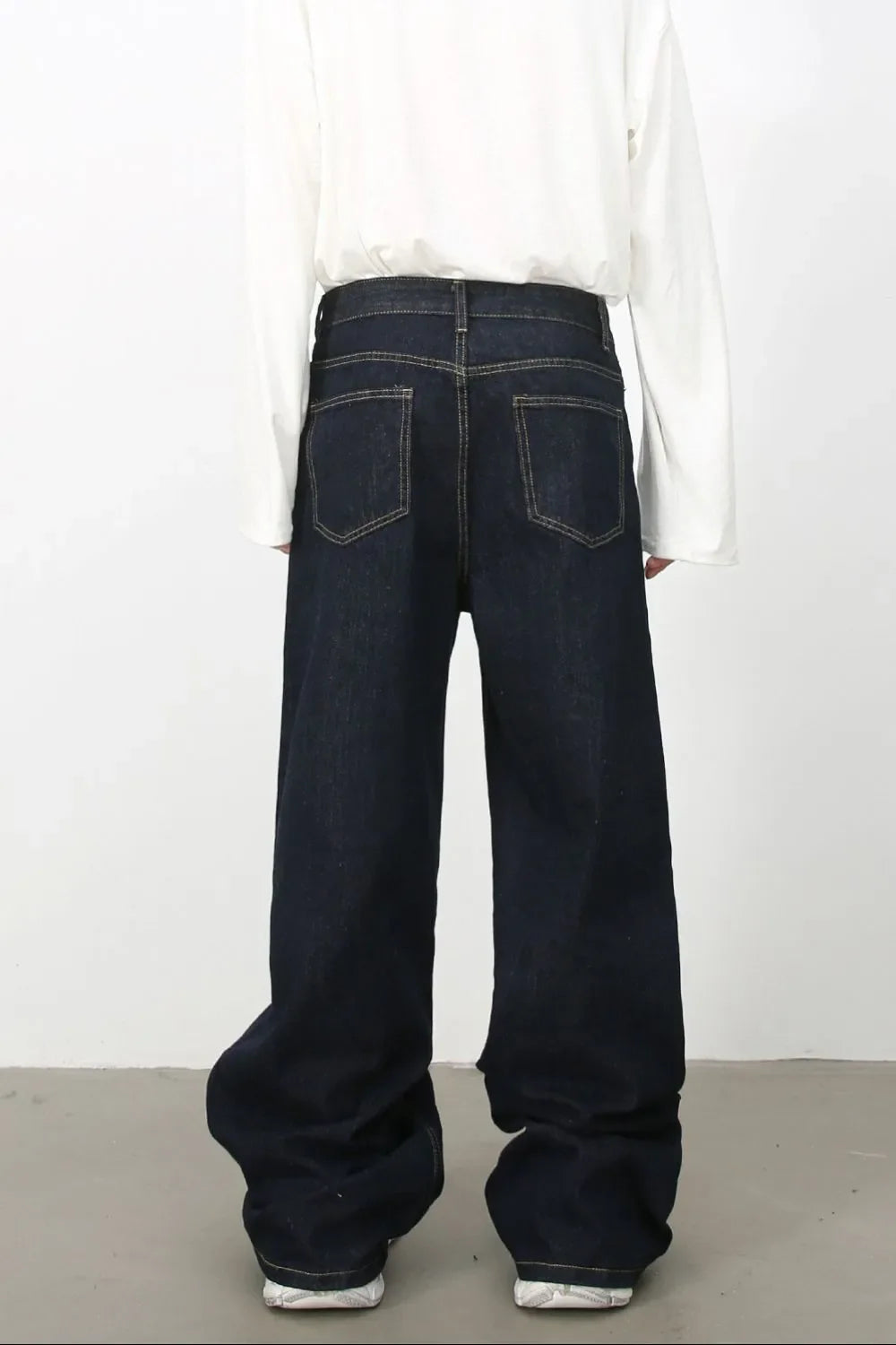 Dark denim trousers with sculptural seam detail and wide leg