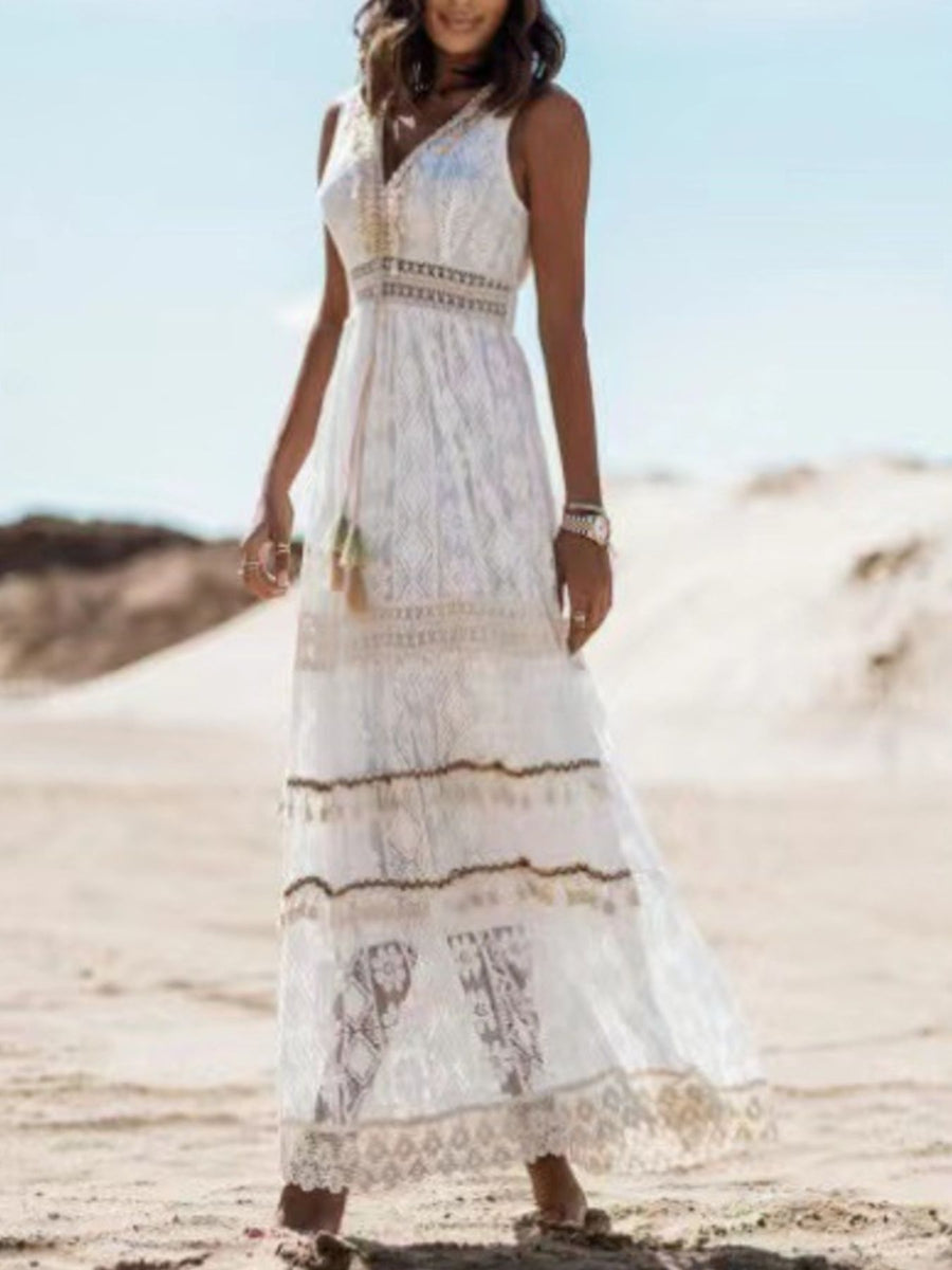 White lace V-neck maxi dress with tiered skirt and tassel detail.