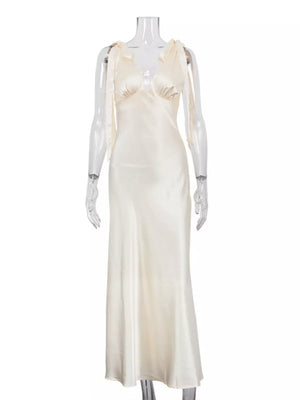 Cream satin slip dress with tie shoulder straps and a V-neckline.