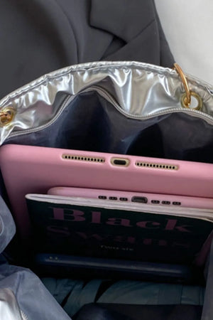 Silver quilted nylon tote bag interior with pink tablet and book