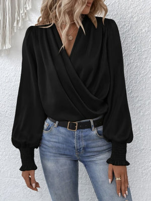 Black ruched surplice blouse with V-neck and bishop sleeves with smocked cuffs.