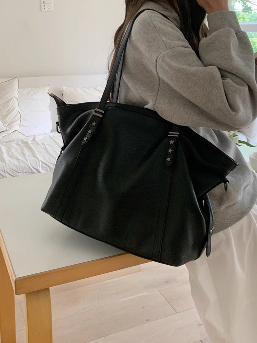 Black pu leather tote bag with star stud details and double straps.