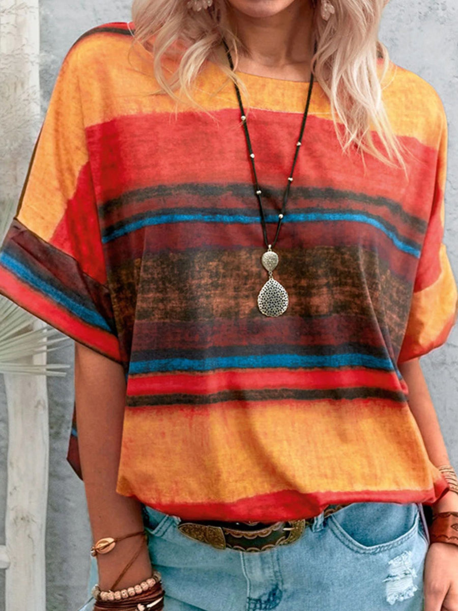 T-shirt with brushstroke stripes in orange, red, blue, and brown. Casual short-sleeve top.