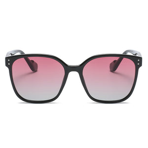Chic oversized black sunglasses with pink gradient lenses and silver dot details.