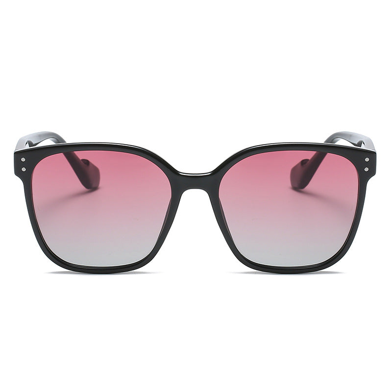 Chic oversized black sunglasses with pink gradient lenses and silver dot details.