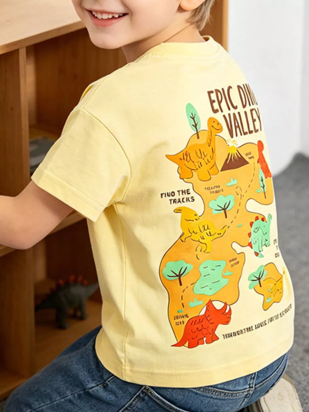 Yellow cotton t-shirt with a dinosaur map graphic and text.