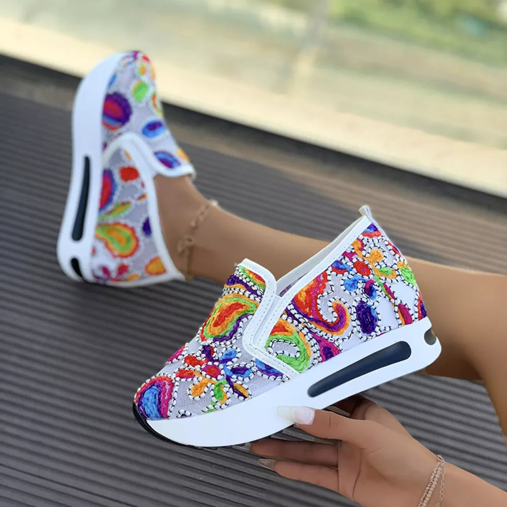 White paisley print platform slip-on shoes with chunky sole and colorful embroidery.