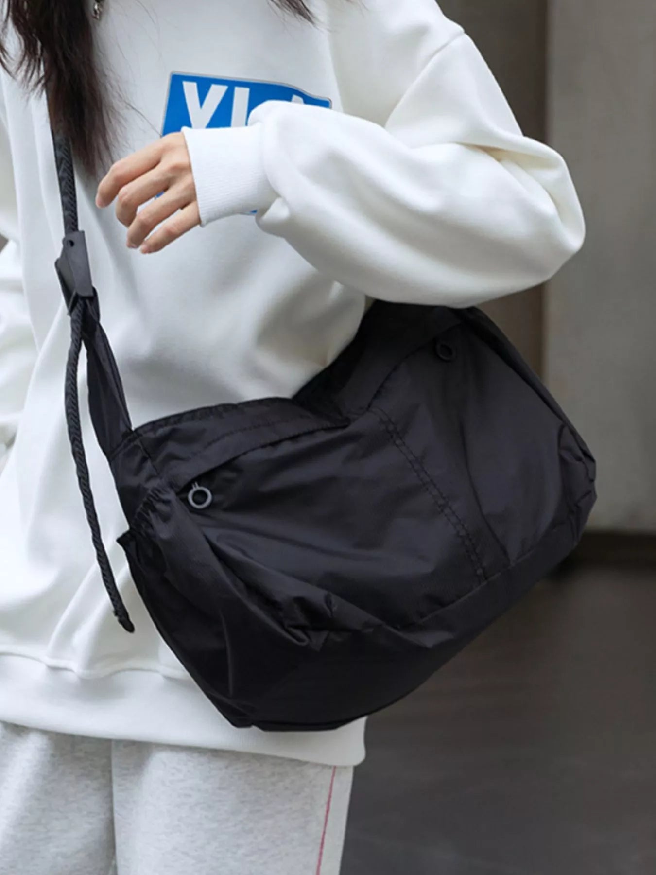 Black nylon casual crossbody bag with adjustable strap and zippered pocket