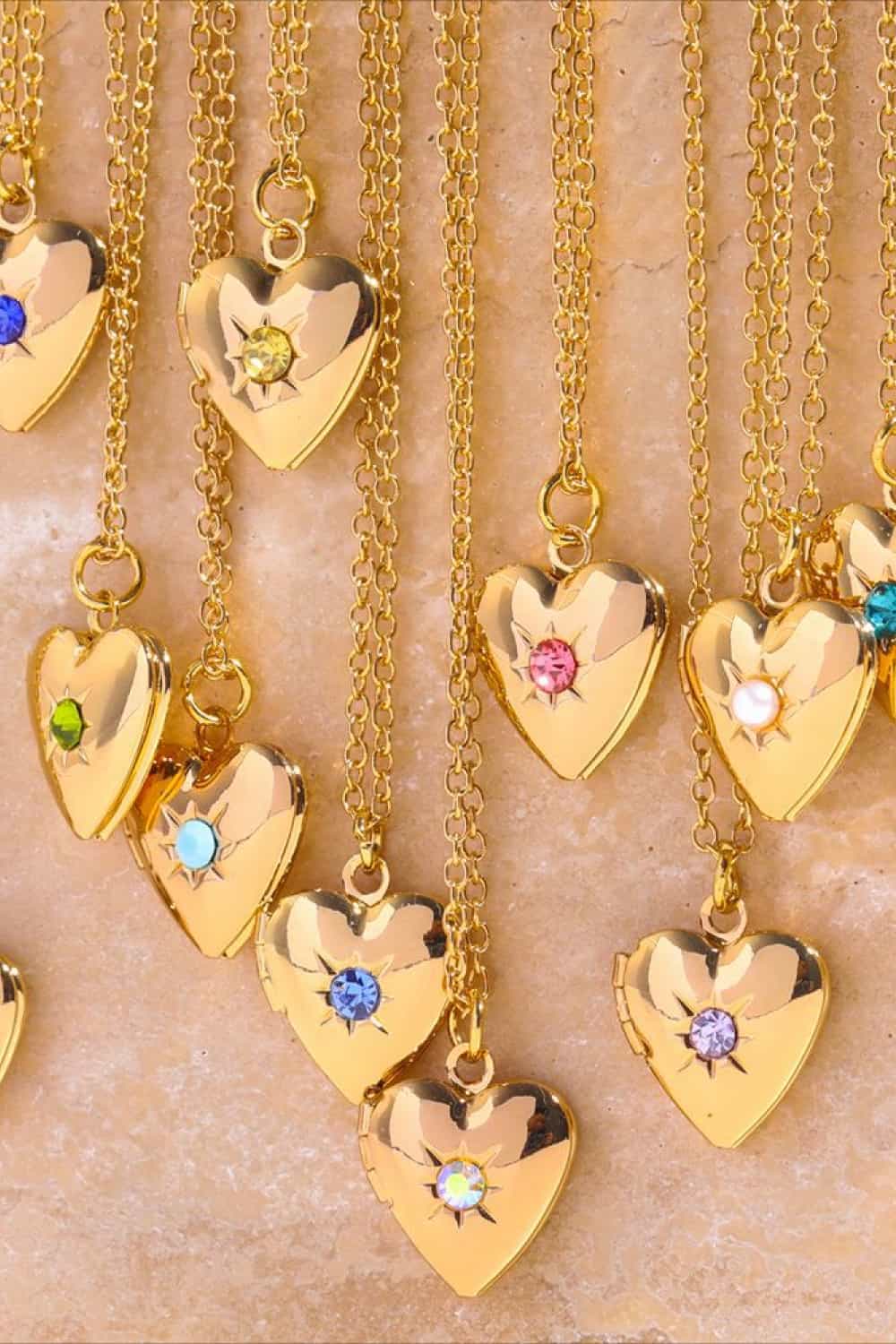 Gold heart locket necklaces with colorful gemstone accents and delicate chains.