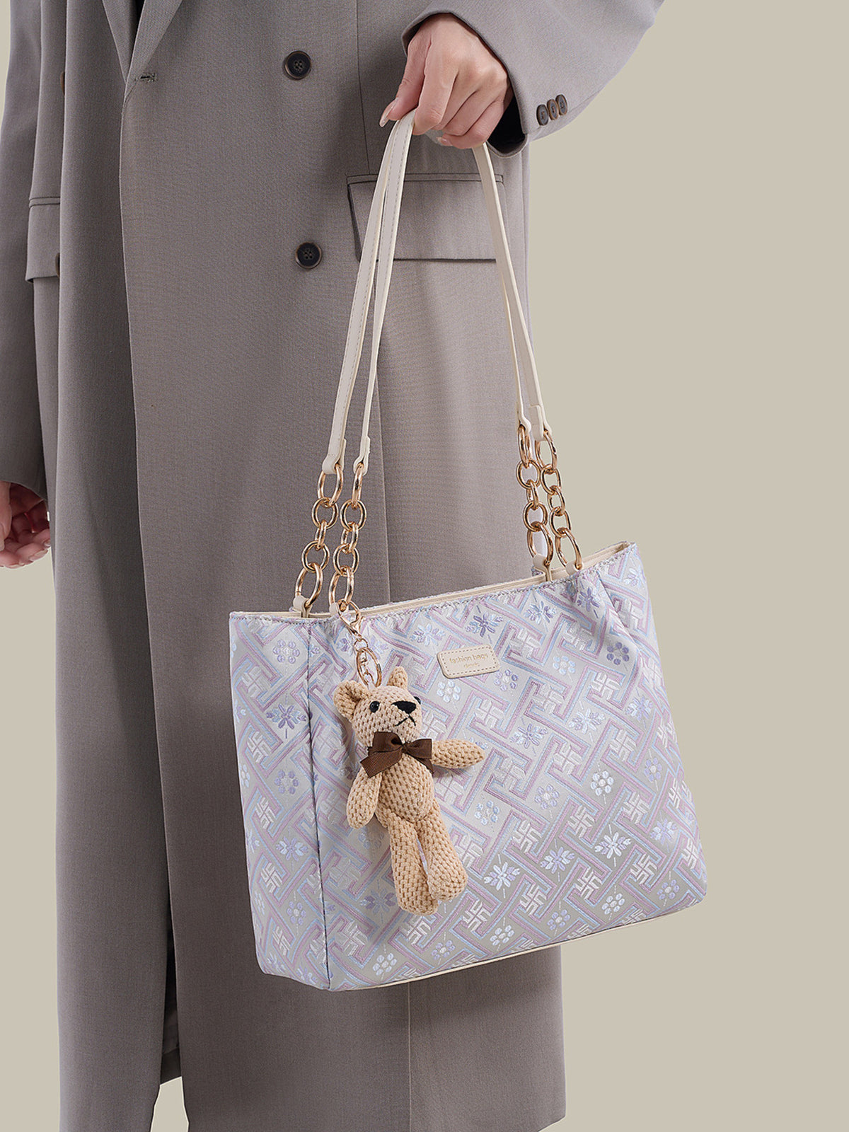 light purple handbag featuring detachable charm and geometric