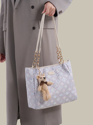 light purple handbag featuring detachable charm and geometric