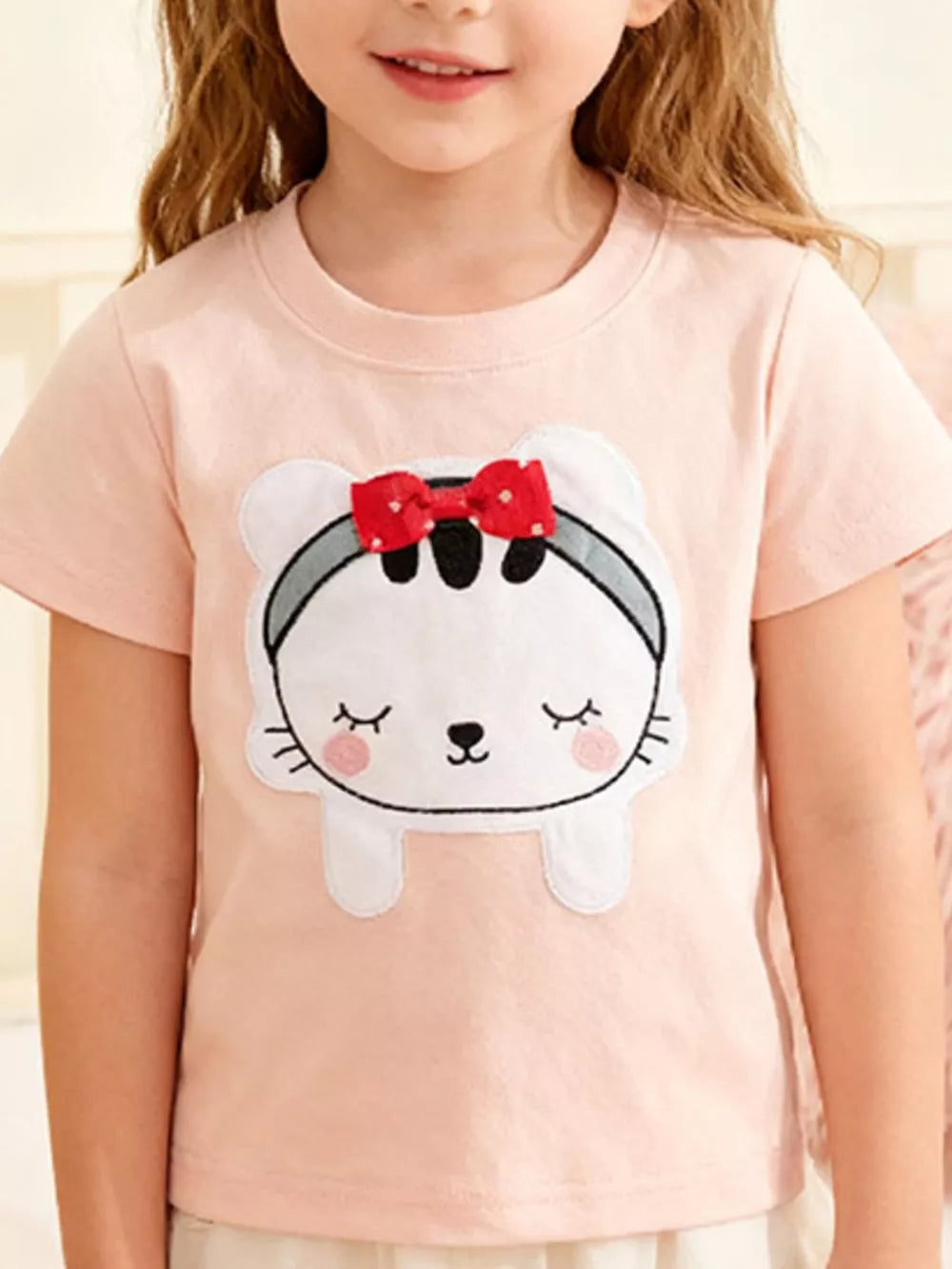 Pink toddler t-shirt with a cute cat appliqué featuring a 3D red bow and closed eyes.