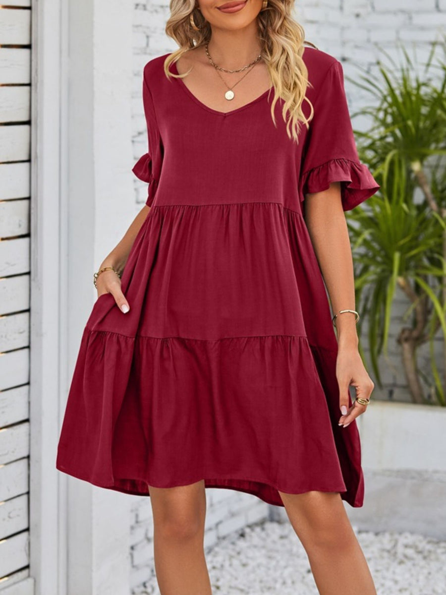 Burgundy ruffled sleeve mini dress with pockets and tiered skirt.