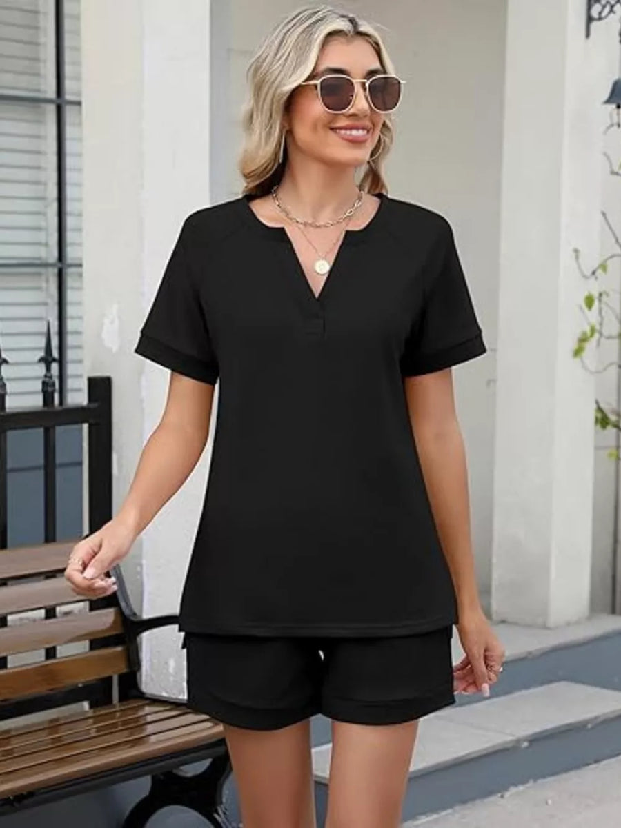 Black relaxed two-piece set with V-neck top and shorts, featuring pockets.