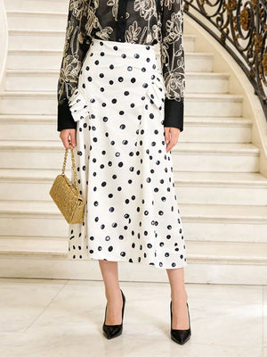 White polka dot midi skirt with ruffled detail and black heels