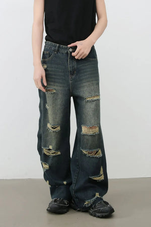 Distressed dark wide leg denim jeans with side slits and frayed hems.
