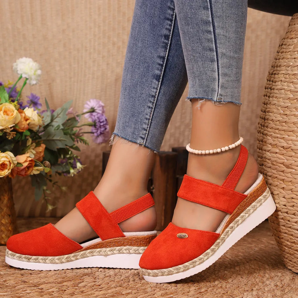 Orange espadrille wedge slingback sandals with a braided jute sole detail.