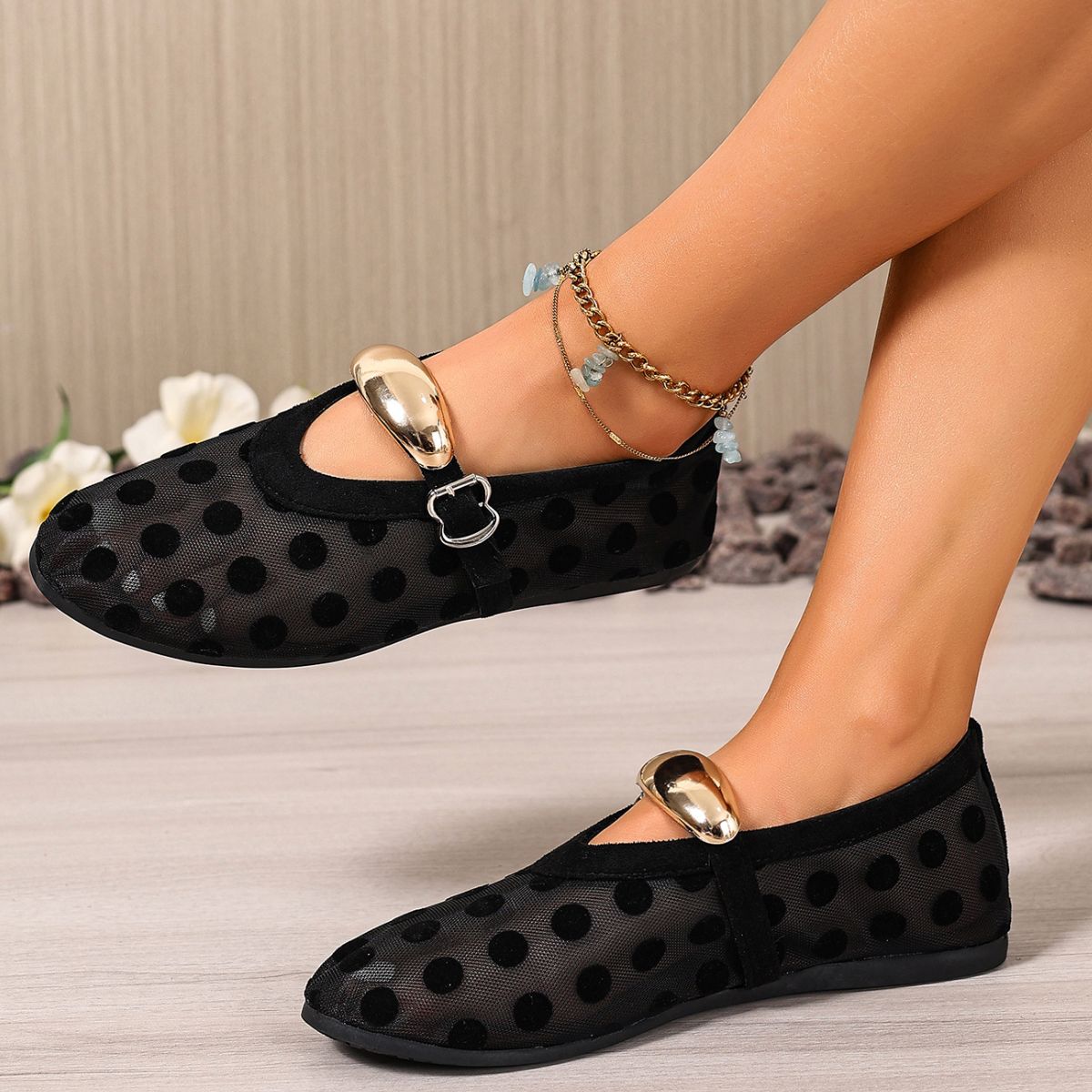 Black polka dot mesh slip-on flats with gold buckle detail and ankle bracelet.