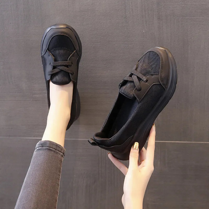 Black mesh and leather platform slip-on flats with a lace-up detail.