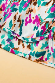 White running shorts with a colorful abstract brushstroke print and white stitching detail.
