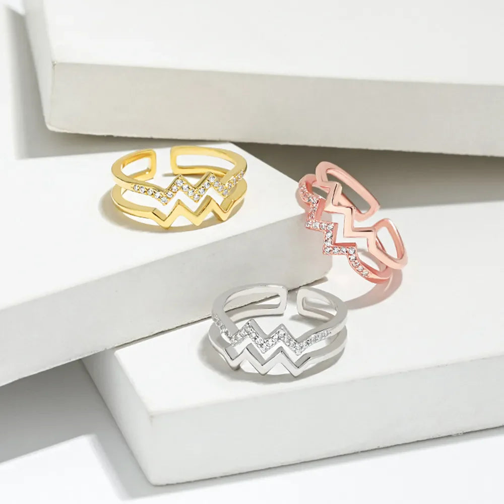 Zigzag split band ring in gold, rose gold, and silver with cubic zirconia accents.