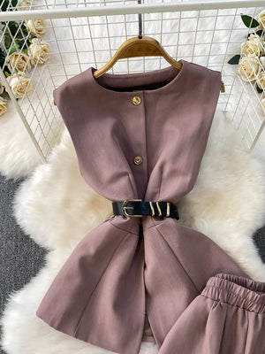 Dusty pink belted two-piece set with gold buttons and black belt.