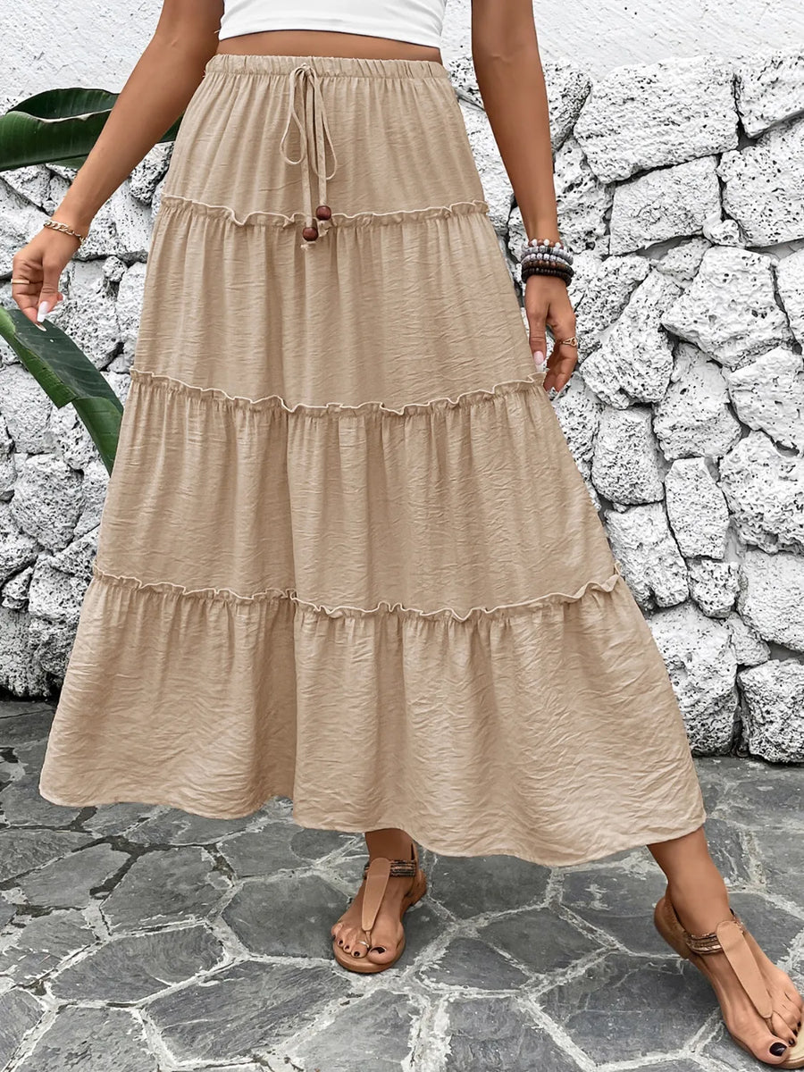 Tiered maxi skirt in tan with drawstring waist and ruffled tiers.