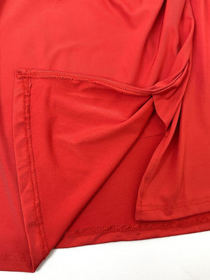 Red jersey wrap skirt with knot detail and visible stitching.
