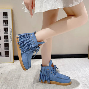 Blue denim moc-toe ankle boots with fringe and studded detailing.