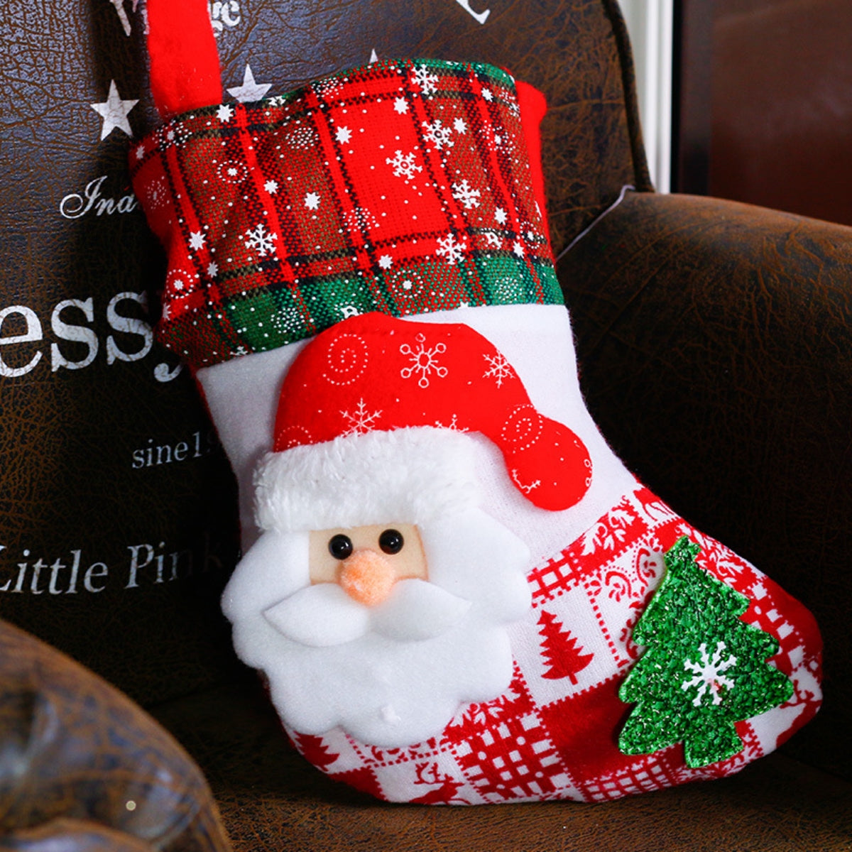 Festive Santa face stocking with red plaid cuff, snowflake pattern, and green Christmas tree applique.