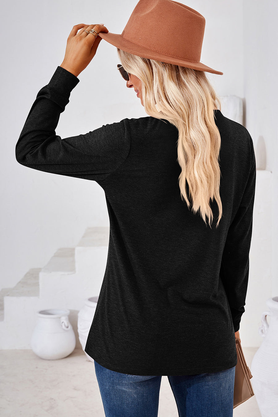 Black Henley button-down knit top with long sleeves and a relaxed fit.
