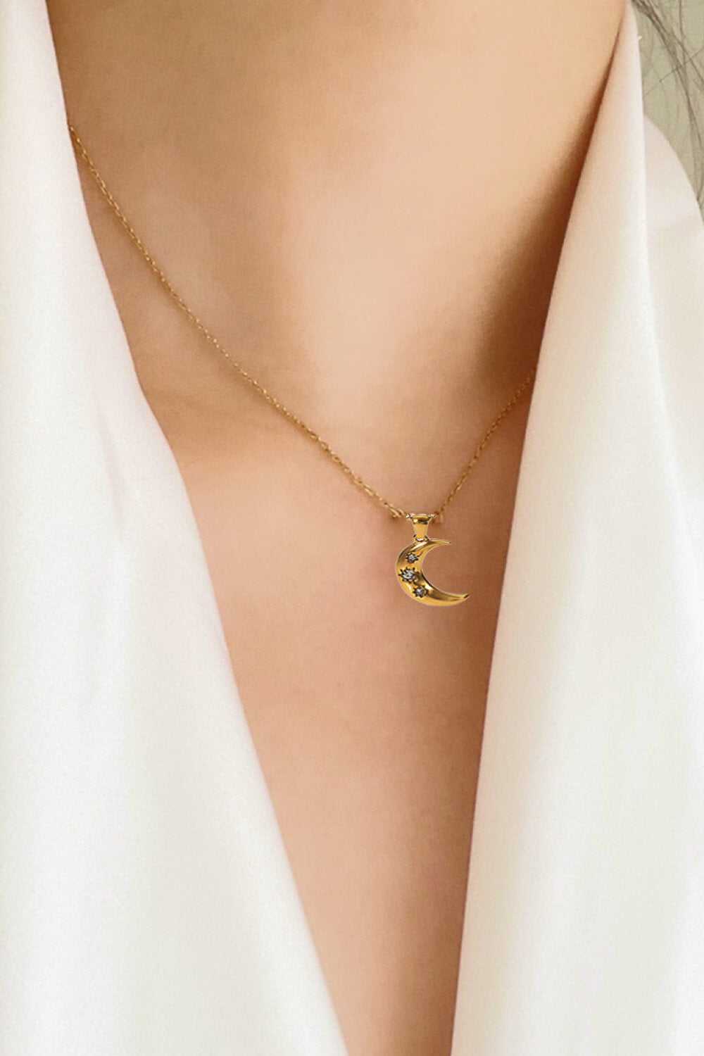 Gold crescent moon pendant necklace with star details on a delicate chain.