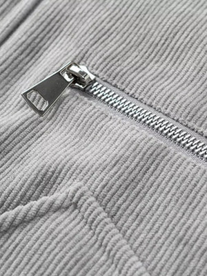 Grey corduroy trucker jacket detail with silver zipper and textured fabric.