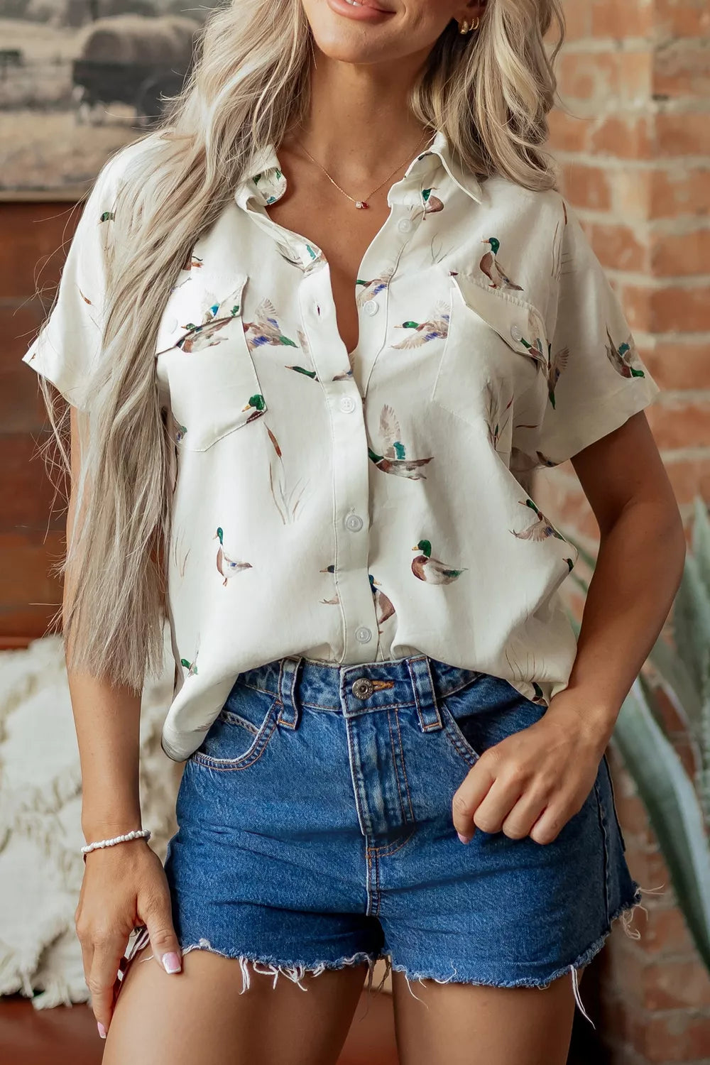 green button-up shirt featuring button-front and animal-print