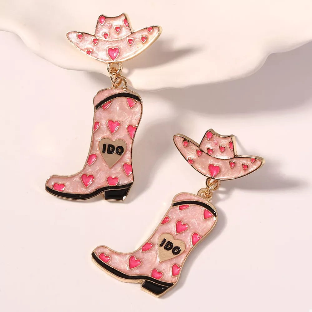Pink cowgirl hat and boot dangle earrings with heart pattern and gold accents.
