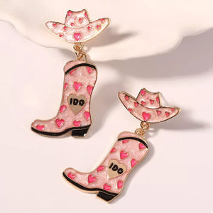 Pink cowgirl hat and boot dangle earrings with heart pattern and gold accents.