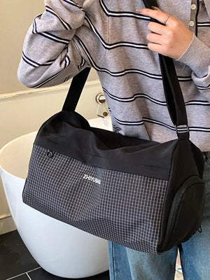 Black travel organizer bag with subtle grid pattern and side zip pocket.
