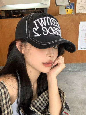 Black distressed baseball cap with white embroidered text and contrast stitching.