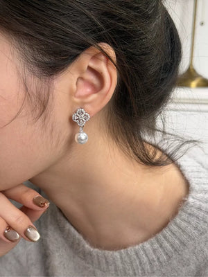 Elegant clover drop earrings with pearl and zircon details.